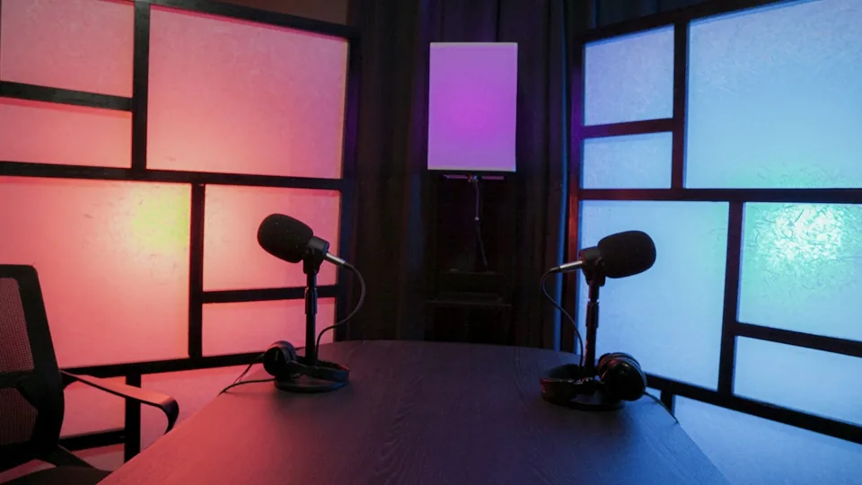 Deux microphones face à face — ambiance podcast illustrative